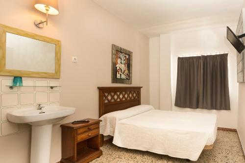 a bathroom with a bed and a sink at Hostel Malaga Inn in Torremolinos