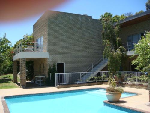 una casa con piscina di fronte a un edificio di Whittlers Lodge a Hout Bay