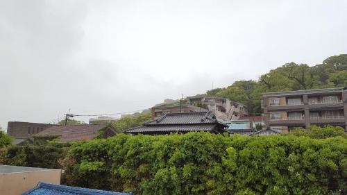 a group of buildings on a hill with trees at Pension Baden Heim in Nagasaki