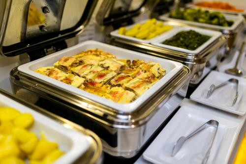 a buffet with several trays of food on a table at Art Deco WOLKER by ASTORIA Hotel & Medical Spa in Karlovy Vary