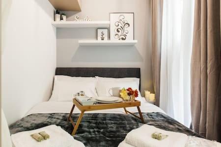 a bedroom with a bed with a table on it at Cozy studio 50m from sea in Athens