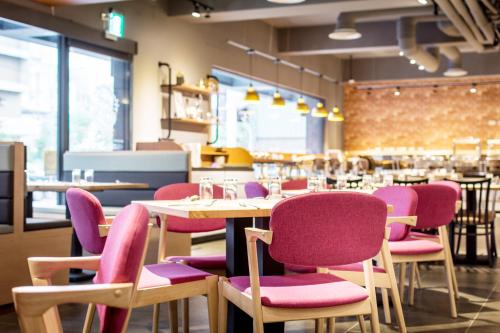 a restaurant with pink and purple chairs and tables at Hotel Liyaou in Chiayi City