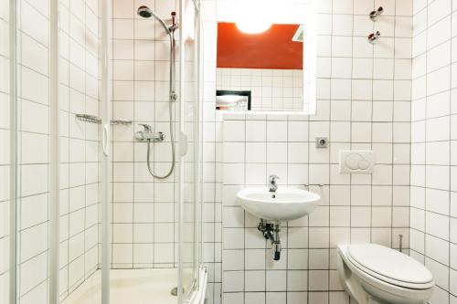 a bathroom with a shower and a toilet and a sink at Hotel U Tří volů in Lysice