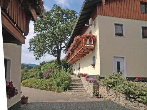 un edificio con balcón y flores. en Birkenhof, en Neukirchen beim Heiligen Blut