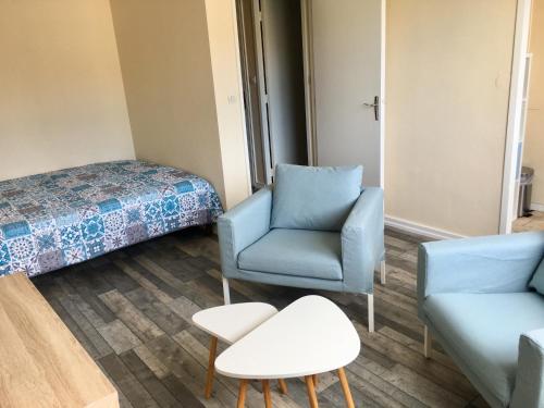 Cette chambre comprend un lit, un canapé et une chaise. dans l'établissement Studio Richelieu 2 et son parking privé, à Villeurbanne