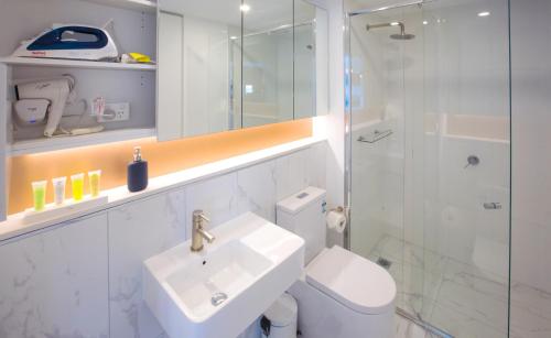 a bathroom with a toilet and a sink and a shower at Spencer Street Apartments in Melbourne