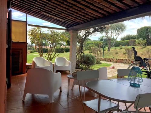 a patio with a table and chairs and a view of a field at Un angolo di paradiso a due passi dal mare in Capo Coda Cavallo