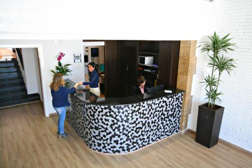 a group of people standing at a reception desk at Hotel Vela in Roses