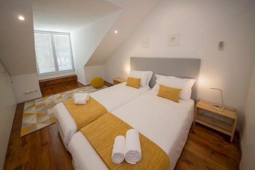 Schlafzimmer mit einem großen weißen Bett und Holzböden in der Unterkunft A Captivating Apartment close to River Tagus in Lisbon in Lissabon