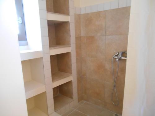 a bathroom with a shower with shelves in it at Arapakis apartment 2 in Aegina Town