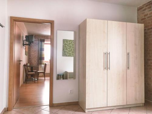 a large wooden cabinet in a living room with a mirror at Penzion Solnice in Znojmo