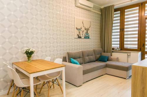 uma sala de estar com um sofá e uma mesa em Apartamenty Roztocze em Zwierzyniec