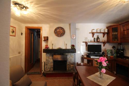 uma sala de estar com uma lareira, uma mesa e uma televisão em Il Castello em Nebbiuno