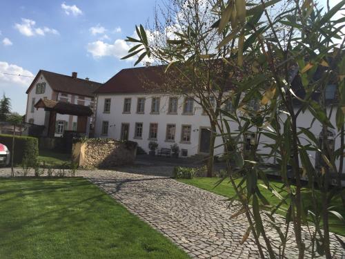 a large white house with a cobblestone driveway at Klosterhof Weingut BoudierKoeller in Stetten
