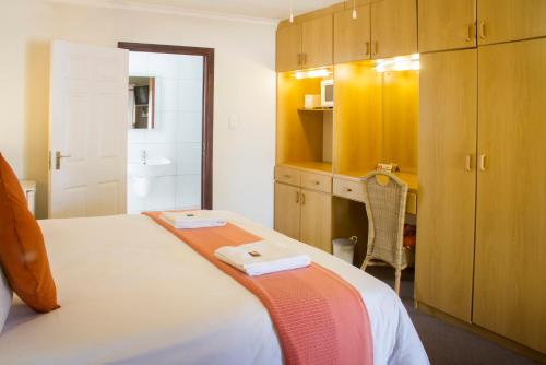 a bedroom with a bed and a bathroom at Albert Road Garden Guest House in Port Elizabeth