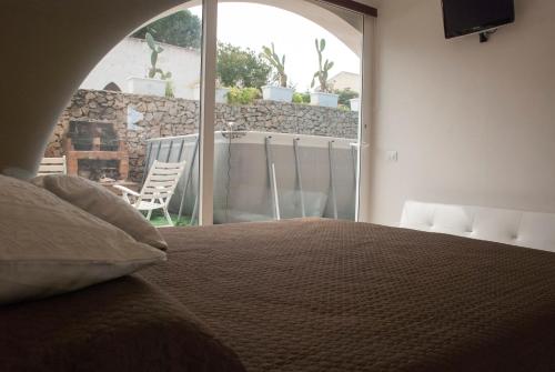 a bedroom with a bed and a view of a patio at Villa sul porto in San Vito lo Capo