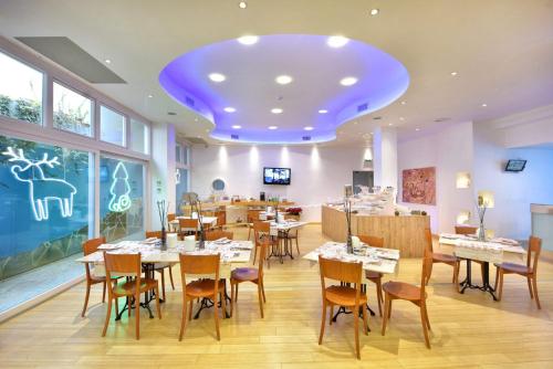 a restaurant with tables and chairs and a purple ceiling at Hotel d'Altavilla in Canosa di Puglia