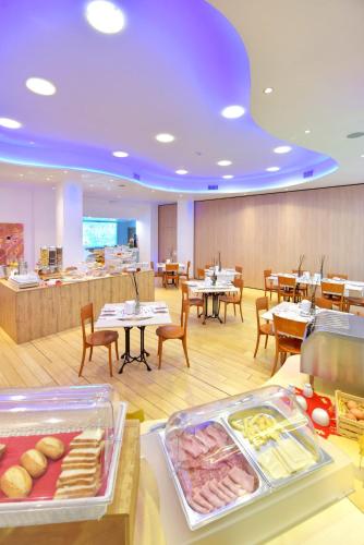 a restaurant with tables and chairs and a buffet at Hotel d'Altavilla in Canosa di Puglia