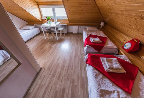 a attic room with two beds and a table at Pension Nika in Prague
