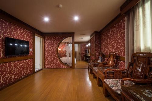 a living room with red walls and a mirror at Golden Phoenix Hotel in Kaohsiung