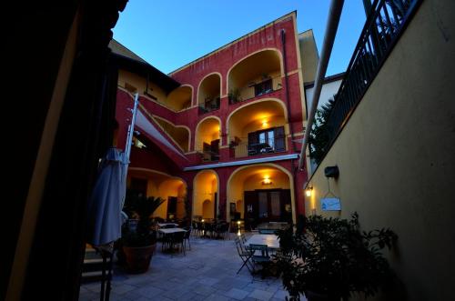 a building with tables and chairs in a courtyard at Manouche Osteria B&B in Caserta