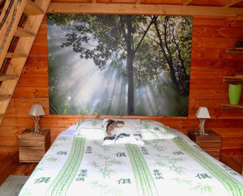 a bed in a room with a large painting on the wall at Chambres d'Hôtes Le Nid d'Iroise in Lanildut
