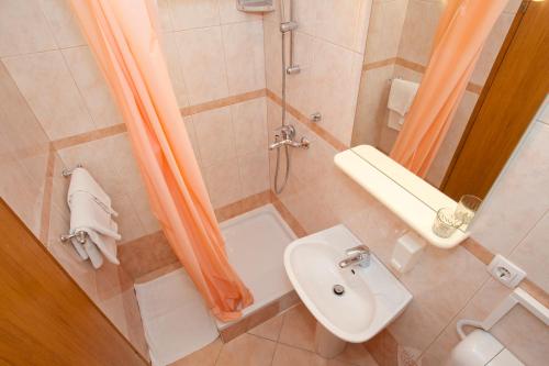 uma casa de banho com um chuveiro, um WC e um lavatório. em Pansion Burin em Baska
