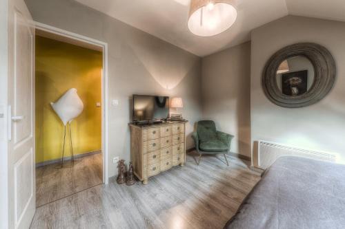 a bedroom with a bed and a chair and a mirror at Gite "le millésime" in Épernay