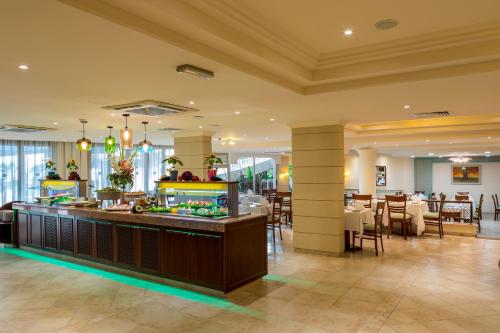 ein Restaurant mit Buffet in der Mitte eines Zimmers in der Unterkunft Aquamare Beach Hotel & Spa in Paphos City