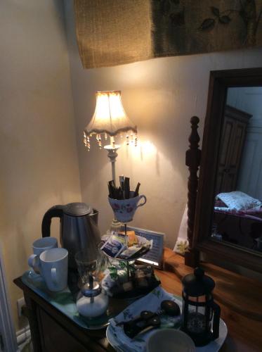 a table with a lamp and a tea kettle on it at Cheltenham Lawn and Pittvile Gallery in Cheltenham