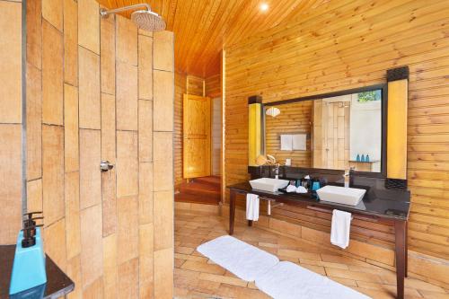 a bathroom with two sinks and a mirror at Komandoo Island Resort & Spa in Komandoo