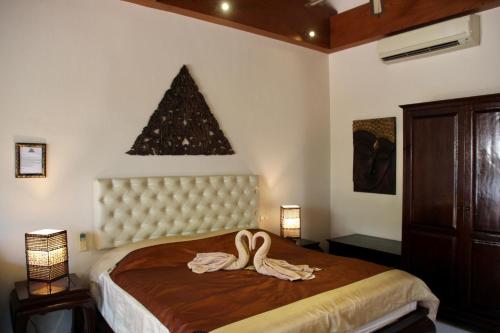 Un dormitorio con una cama con dos cisnes. en Sibaja Palms Sunset Beach Luxury Apartments, en Taling Ngam