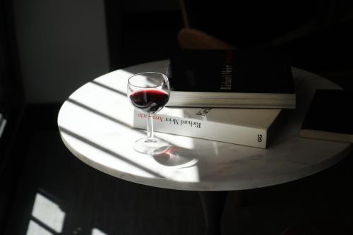 a glass of wine sitting on a table next to a book at MD Design Hotel - Portal del Real in Valencia