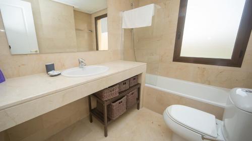 a bathroom with a sink and a toilet and a mirror at Coto Real Andros 201 in Manilva