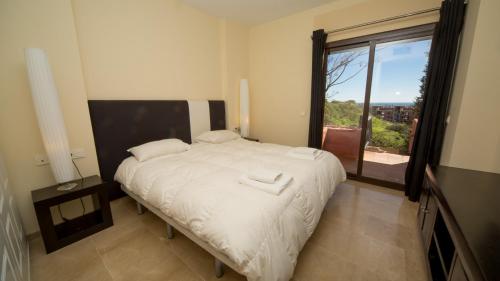 マニルバにあるCoto Real Khios 102のベッドルーム1室(大きなベッド1台、大きな窓付)