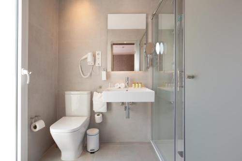 a bathroom with a toilet and a sink and a shower at Hostal Centric in Barcelona