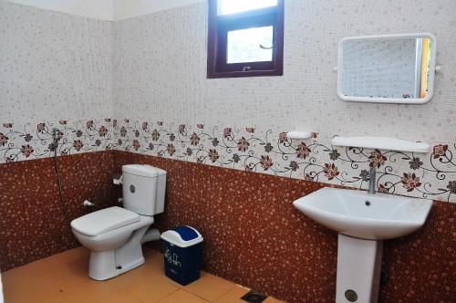 a bathroom with a toilet and a sink at Little Swan Guest house in Bentota