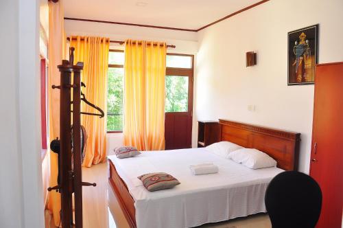 1 dormitorio con cama y ventana en Little Swan Guest house en Bentota