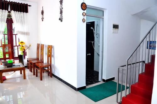 a living room with a staircase and a glass door at Little Swan Guest house in Bentota