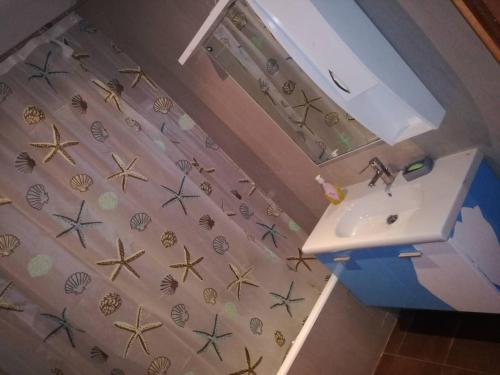 a bathroom with a sink and a shower curtain with starfish at Le luxe du Lac 2 in Berges Du Lac