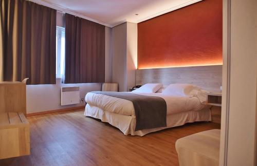 セーにあるHospedium Hotel La Marina Costa da Morteの大きなベッドと窓が備わるホテルルームです。