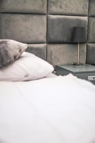 a bed with two pillows and a lamp on a table at Przystanek Zatoka in Olsztyn