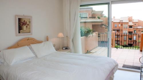 - une chambre avec un lit blanc et un balcon dans l'établissement Los Granados 922, à Manilva
