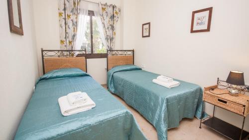 マニルバにあるMarina de la Duquesa 803のベッドルーム1室(ベッド2台、ランプ付きテーブル付)