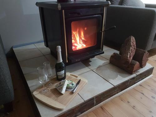 a fireplace with a bottle of wine and two glasses at Paradise by the Beach - Culburra beach in Culburra Beach