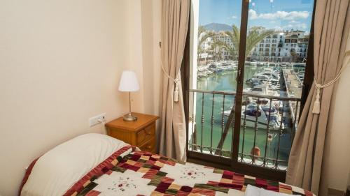 マニルバにあるMarina Real 124のマリーナの景色を望む窓付きのベッドルーム1室