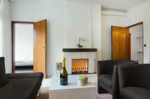 a living room with a bottle of wine and a fireplace at Hotel des Nordens Flensburg Wellness & Spa in Flensburg