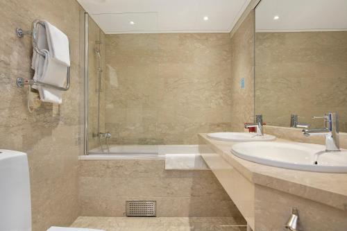 a bathroom with two sinks and a shower at Elite Stadshotellet Luleå in Luleå