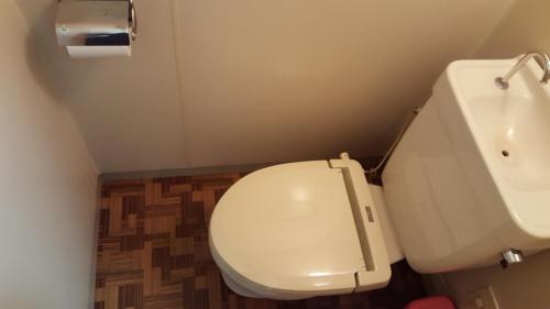 a bathroom with a white toilet and a sink at Pension Baden Heim in Nagasaki