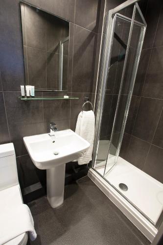 a bathroom with a sink and a shower at Arthur's Bar & Accommodation in Southport